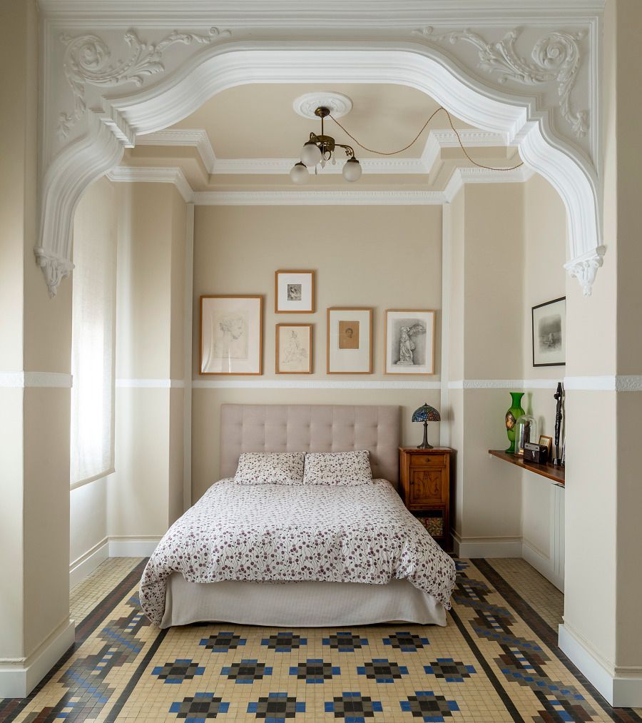 Un dormitorio con una cama y una alfombra en el suelo.