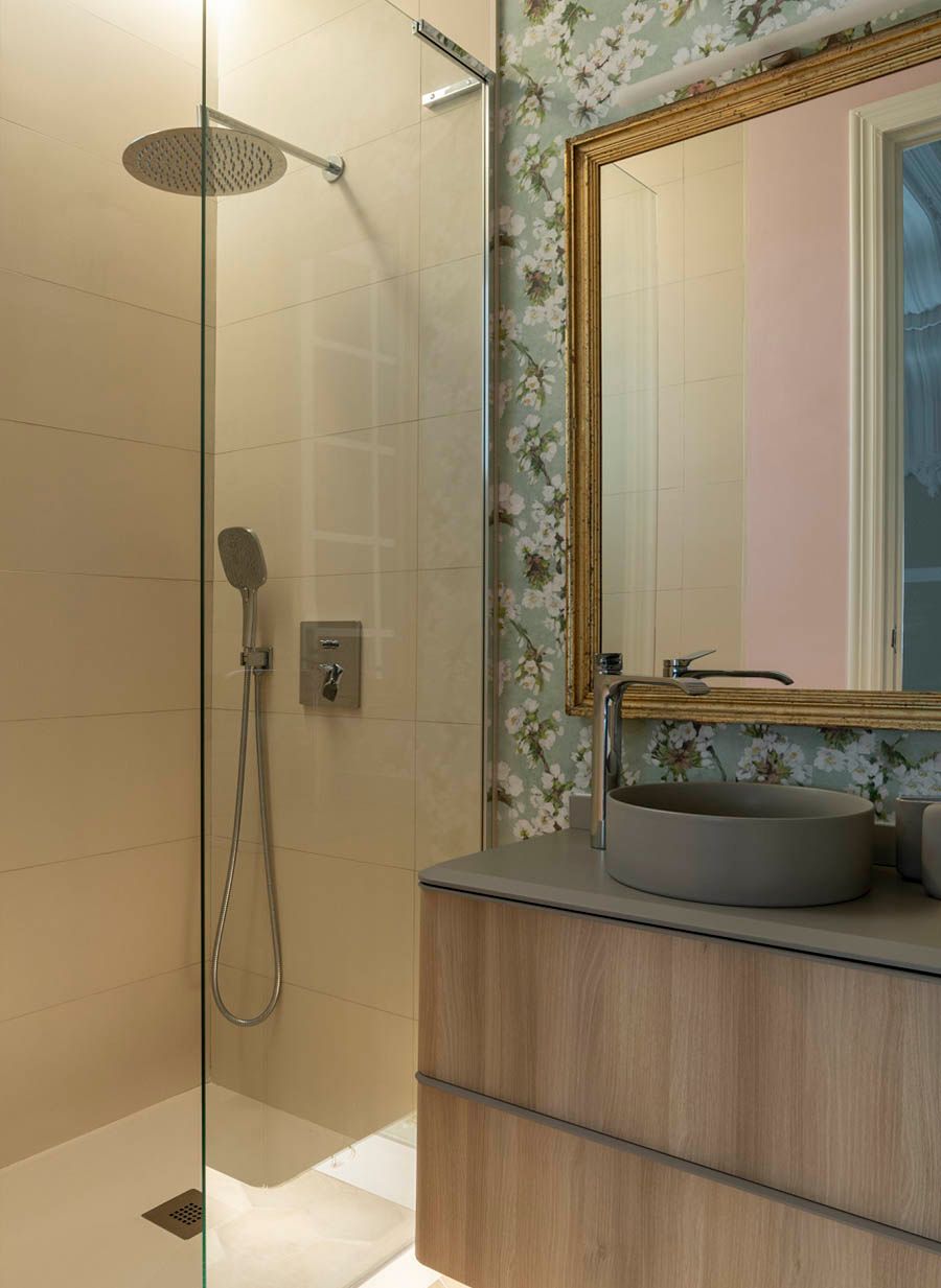 Un baño con ducha, lavabo y espejo.