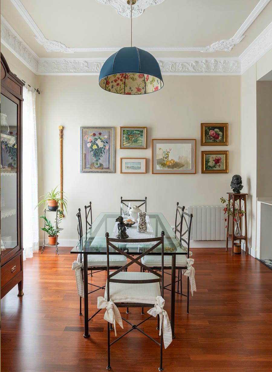 Un comedor con una mesa de cristal y sillas.