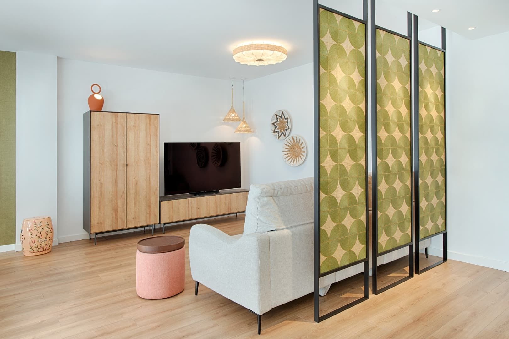Una cama con sábanas blancas y almohadas moradas en un dormitorio.