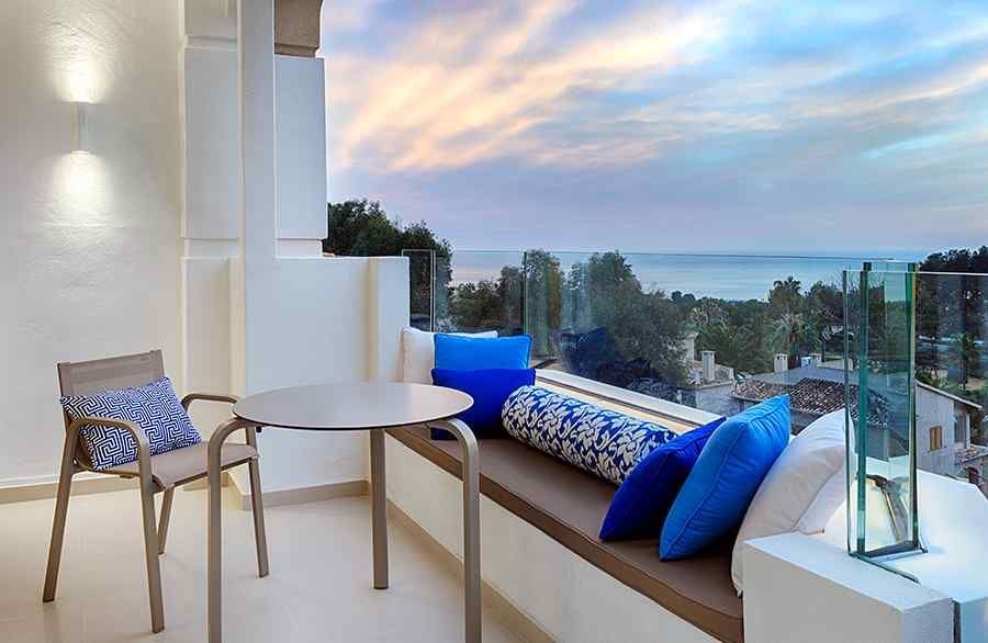 Un balcón con mesa y sillas y vista al mar.