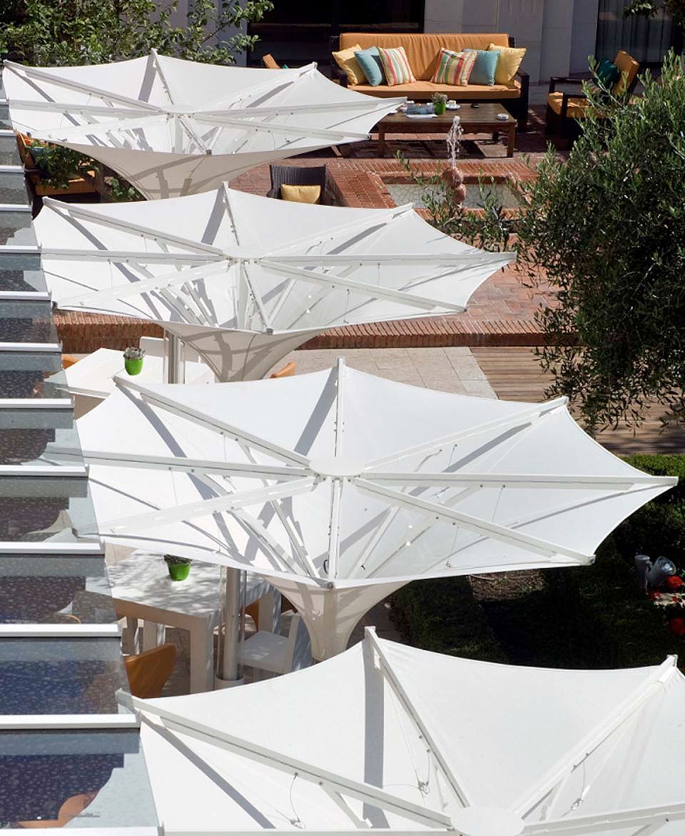 Una fila de sombrillas blancas están alineadas en una fila