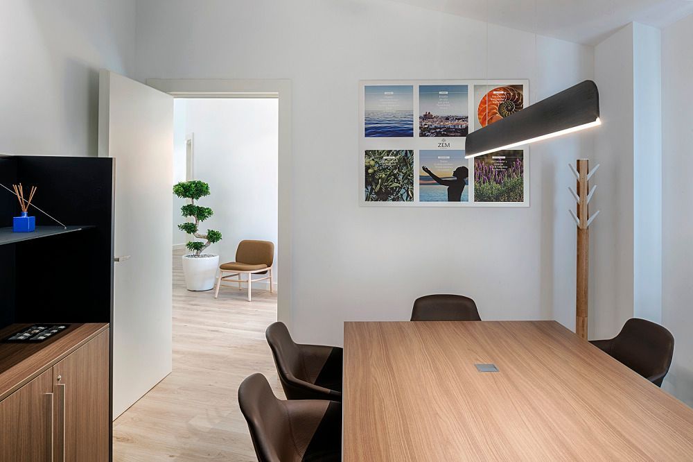 Una sala de conferencias con una mesa y sillas de madera.
