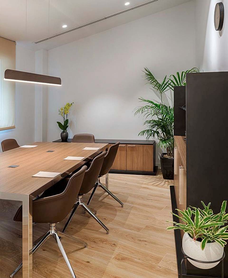 Una sala de conferencias con una larga mesa de madera y sillas.