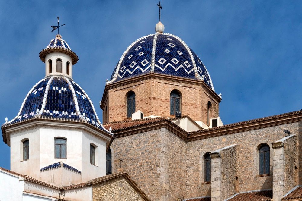 Una iglesia con una cúpula azul y blanca y una cruz en la parte superior