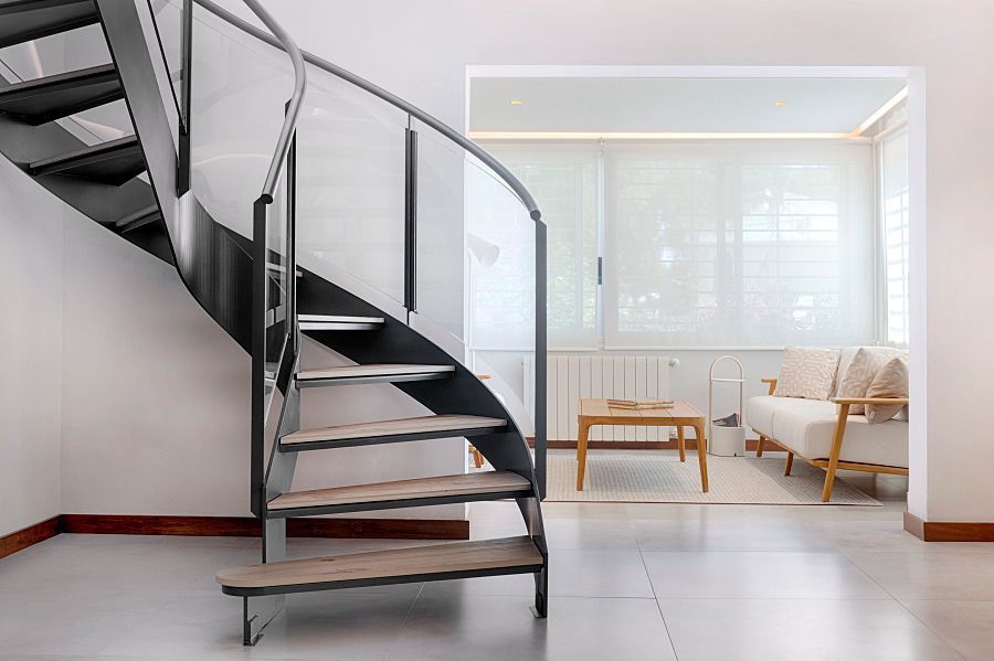 Hay una escalera de caracol en el medio de una sala de estar.