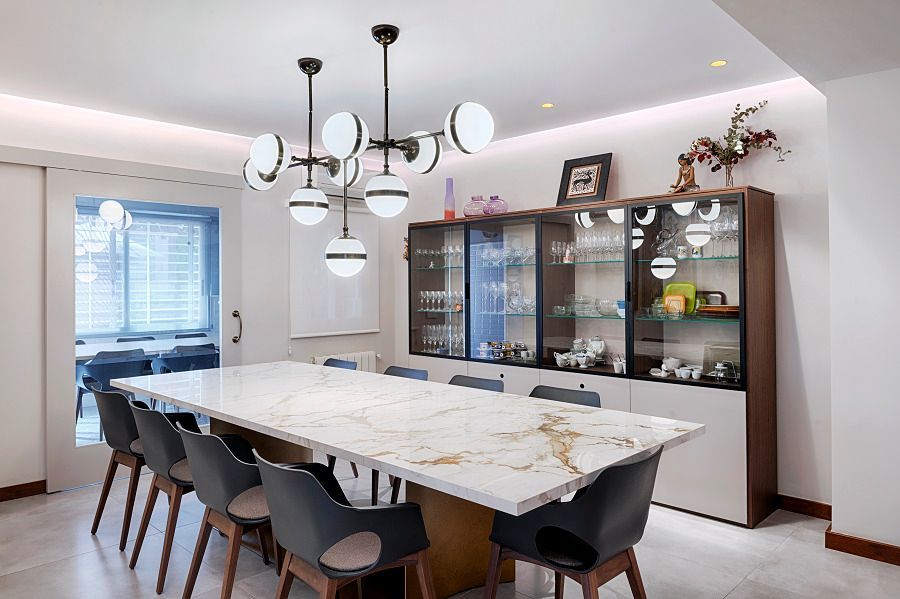 Un comedor con una mesa larga y sillas y una lámpara de araña.