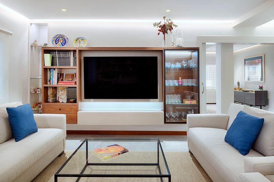 Una sala de estar con dos sofás, una mesa de café y un televisor de pantalla plana.