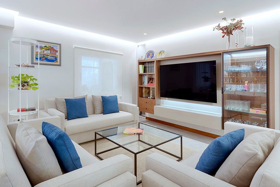 Una sala de estar con dos sofás, una mesa de café y un televisor de pantalla plana.