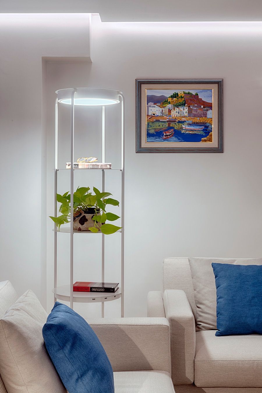 Una sala de estar con un sofá y un cuadro en la pared.