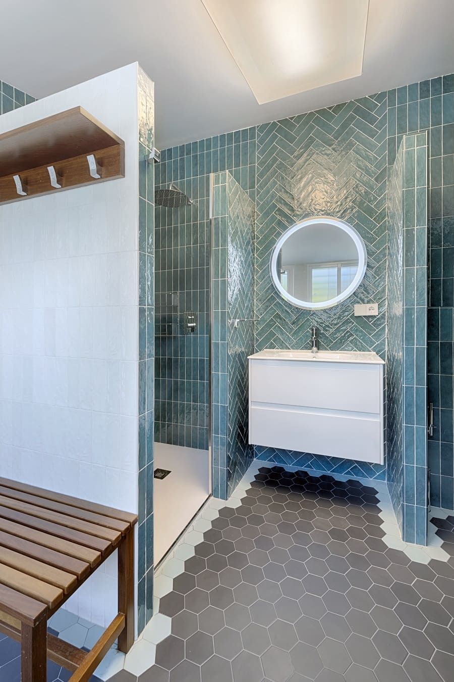 Un baño con lavabo, espejo y ducha.