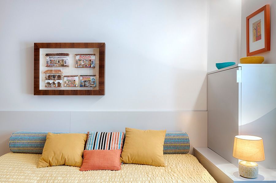 Un dormitorio con una cama y una lámpara y un cuadro en la pared encima de la cama.