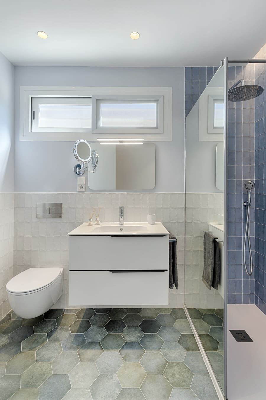 Un baño con lavabo, inodoro, espejo y ducha.