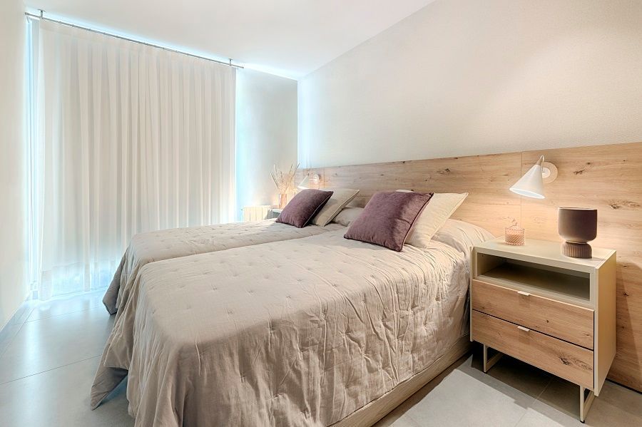 Un dormitorio con dos camas y una mesita de noche.