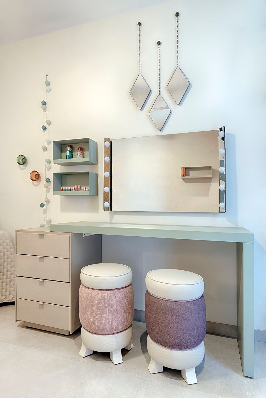 Un tocador con un espejo y dos otomanas en una habitación.