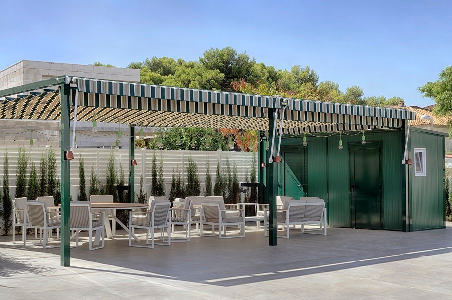 Un patio con mesas y sillas bajo un dosel.