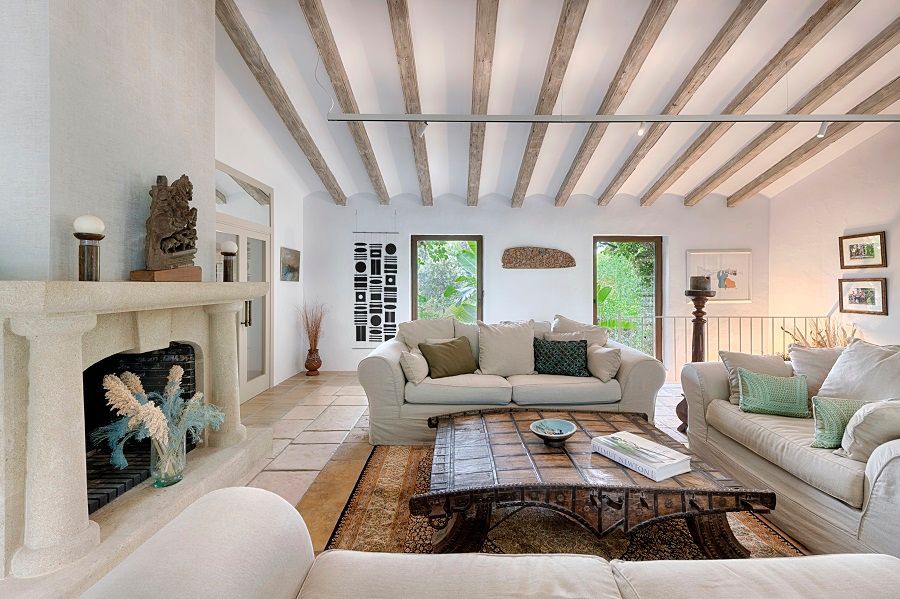 Una sala de estar con muebles blancos y chimenea.