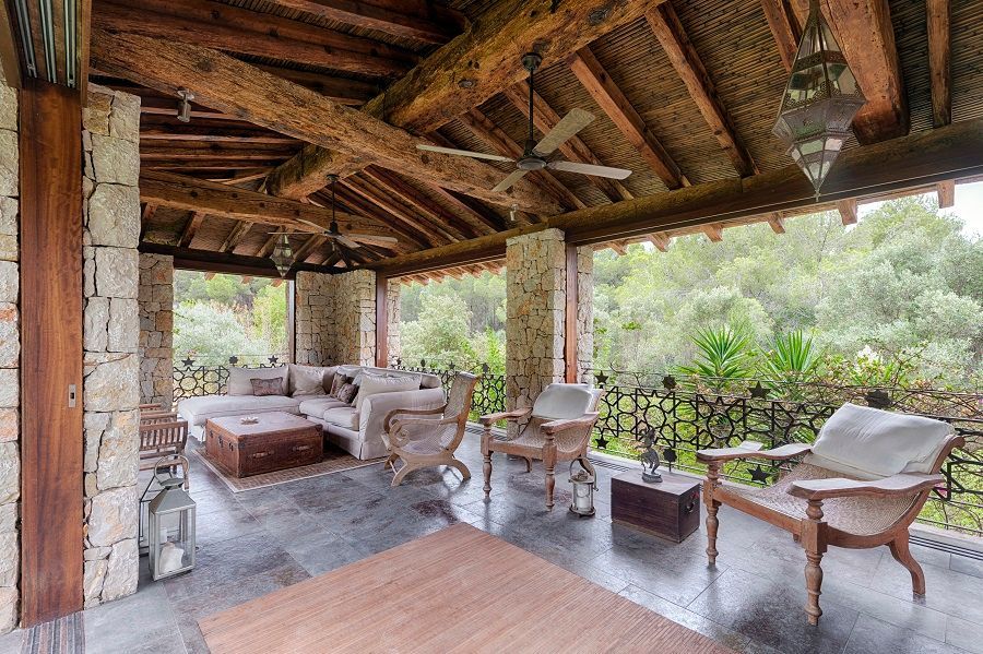 Hay muchas sillas y un sofá en el porche.