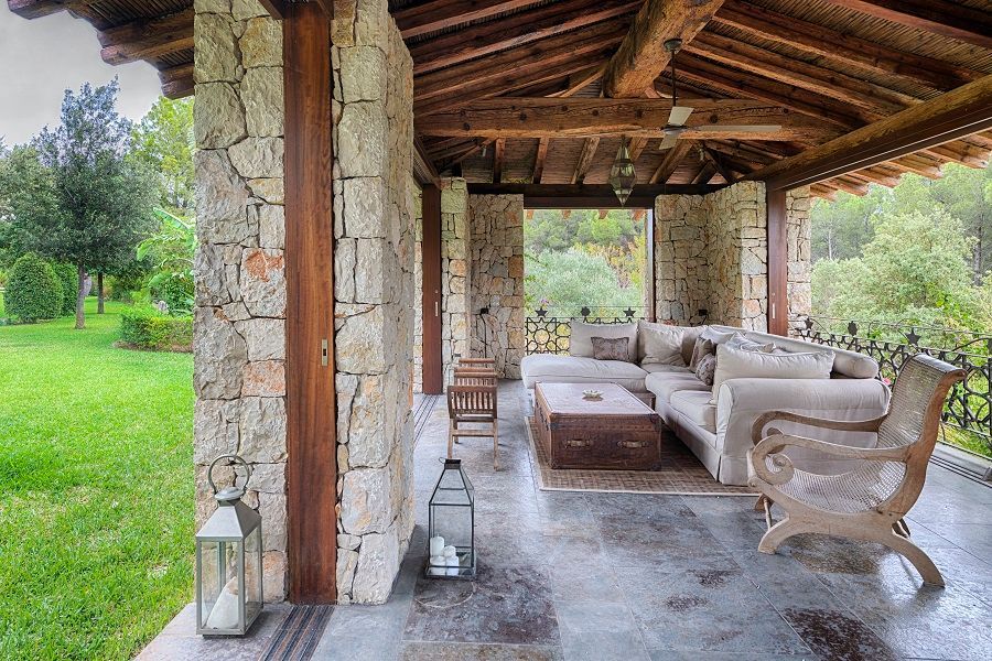 Una sala de estar con un sofá y sillas bajo un techo de madera.