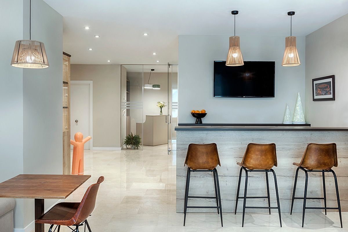 Una sala de estar con una mesa y sillas y un bar.