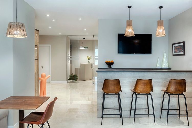 Una sala de estar con una mesa, sillas, taburetes y un televisor de pantalla plana.