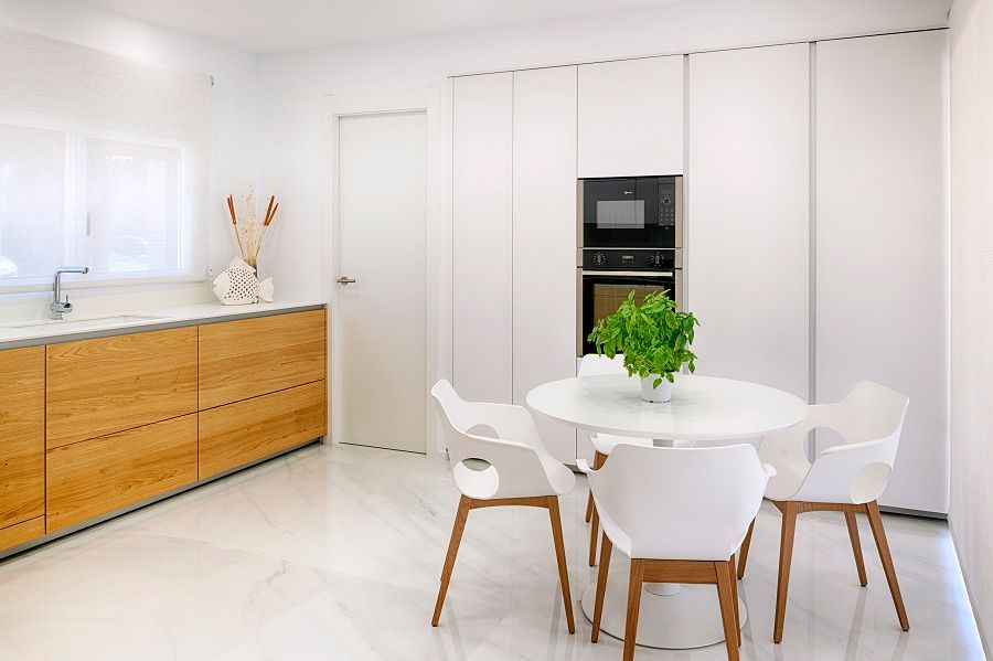 Una cocina con una mesa redonda y sillas y una planta en el medio.