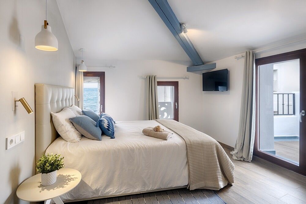 Un dormitorio con una cama king size y un televisor de pantalla plana.