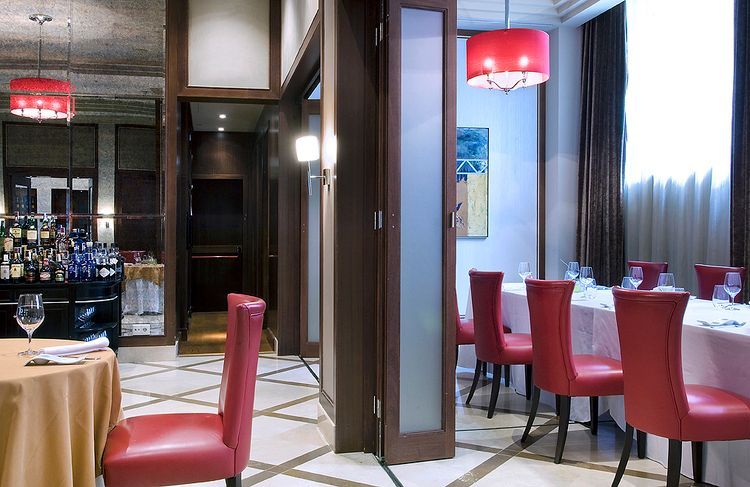 Un comedor con sillas y mesas rojas.