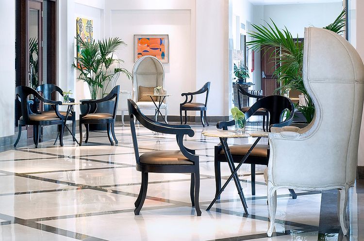 Hay muchas sillas y mesas en el vestíbulo de un hotel.