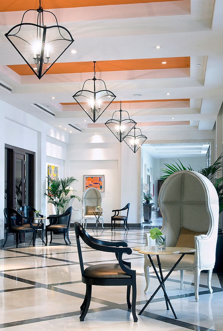 Hay muchas sillas y mesas en el vestíbulo de un hotel.