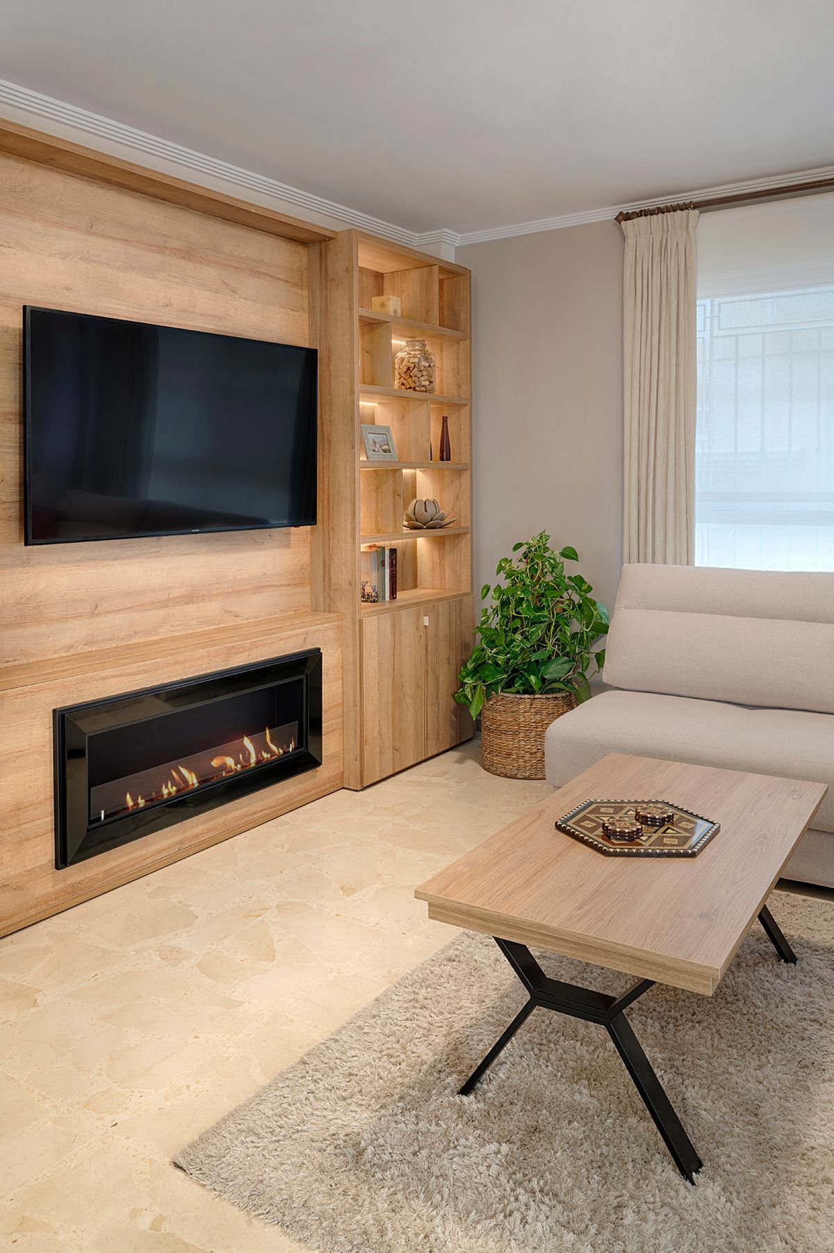 Una sala de estar con sofá, mesa de café, chimenea y televisión.