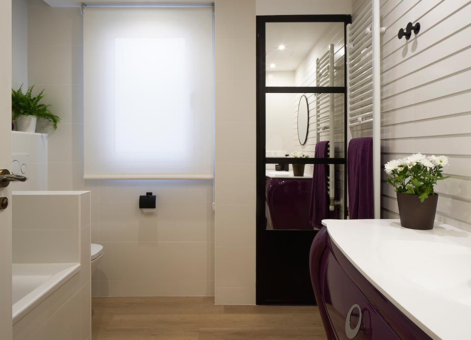 Un baño con bañera, lavabo y espejo.