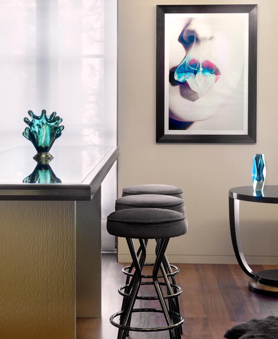 Una imagen del rostro de una mujer cuelga sobre una fila de taburetes de bar.