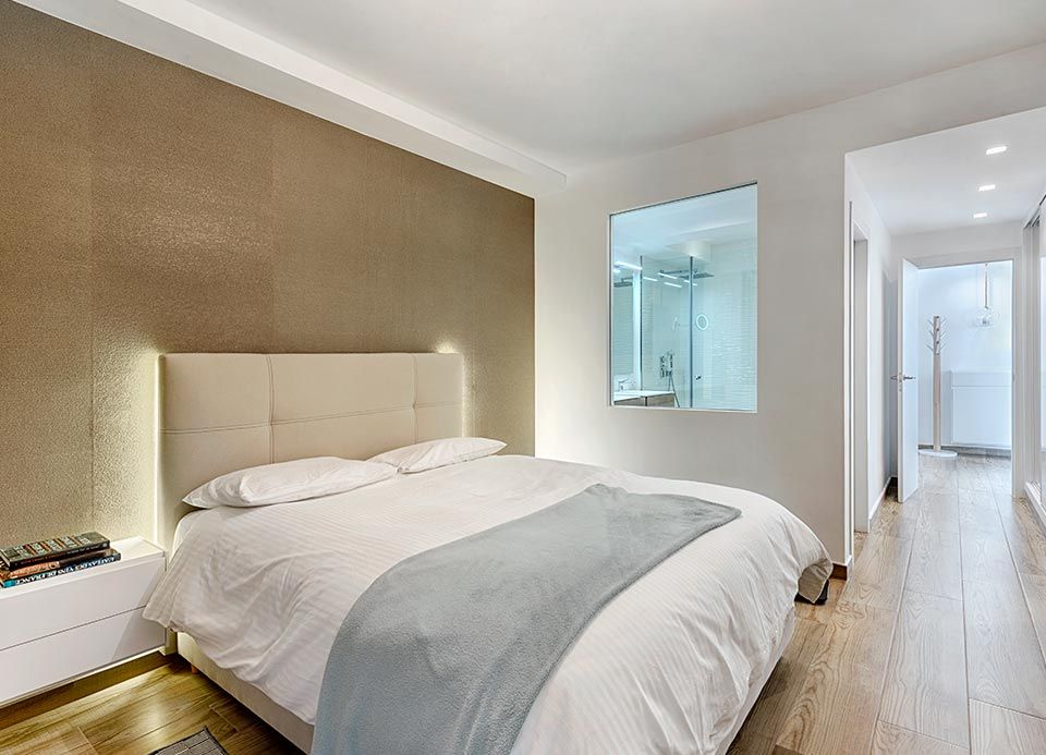 Un dormitorio con una cama grande y una ducha a ras de suelo.