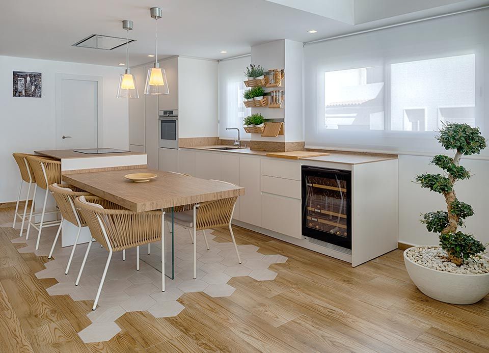 Una cocina con una mesa y sillas y una planta en maceta.