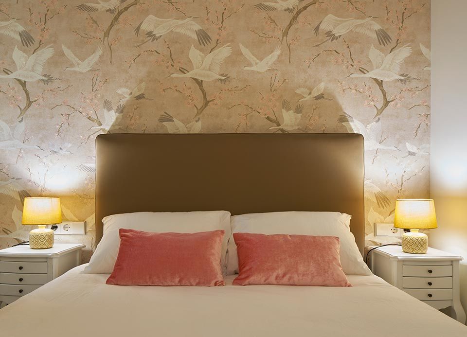 Un dormitorio con una cama y dos mesitas de noche con lámparas.