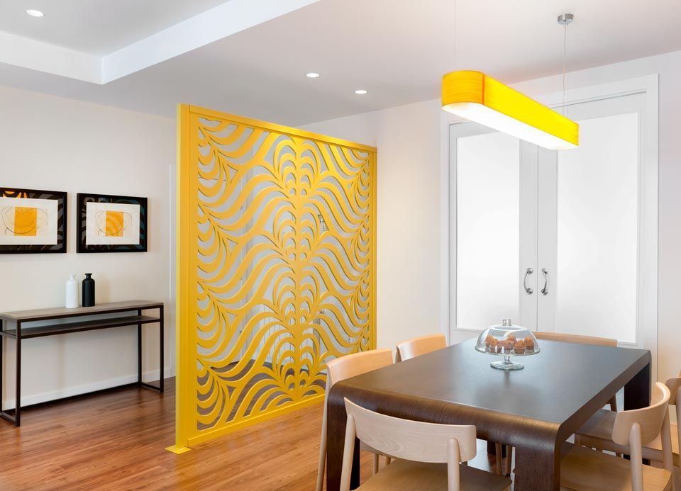 Un comedor con una mesa y sillas y un biombo amarillo.