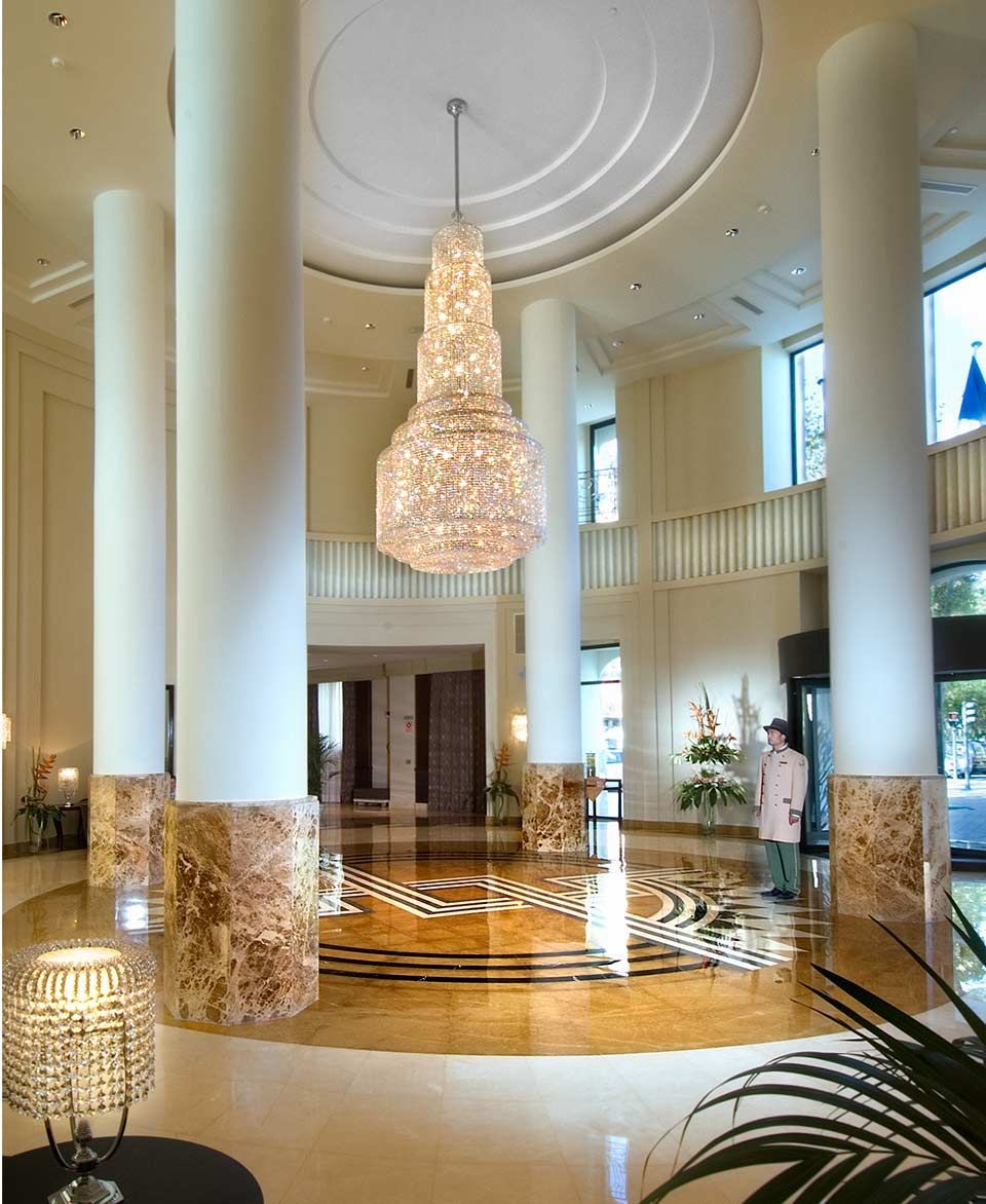Un vestíbulo de hotel con una gran lámpara de araña colgando del techo.