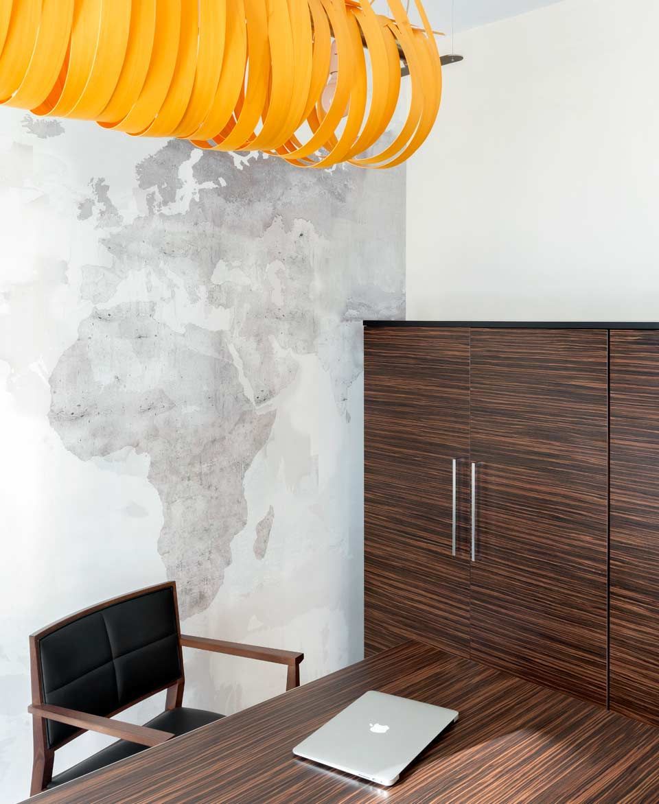 Una computadora portátil se encuentra en un escritorio frente a un mapa del mundo.