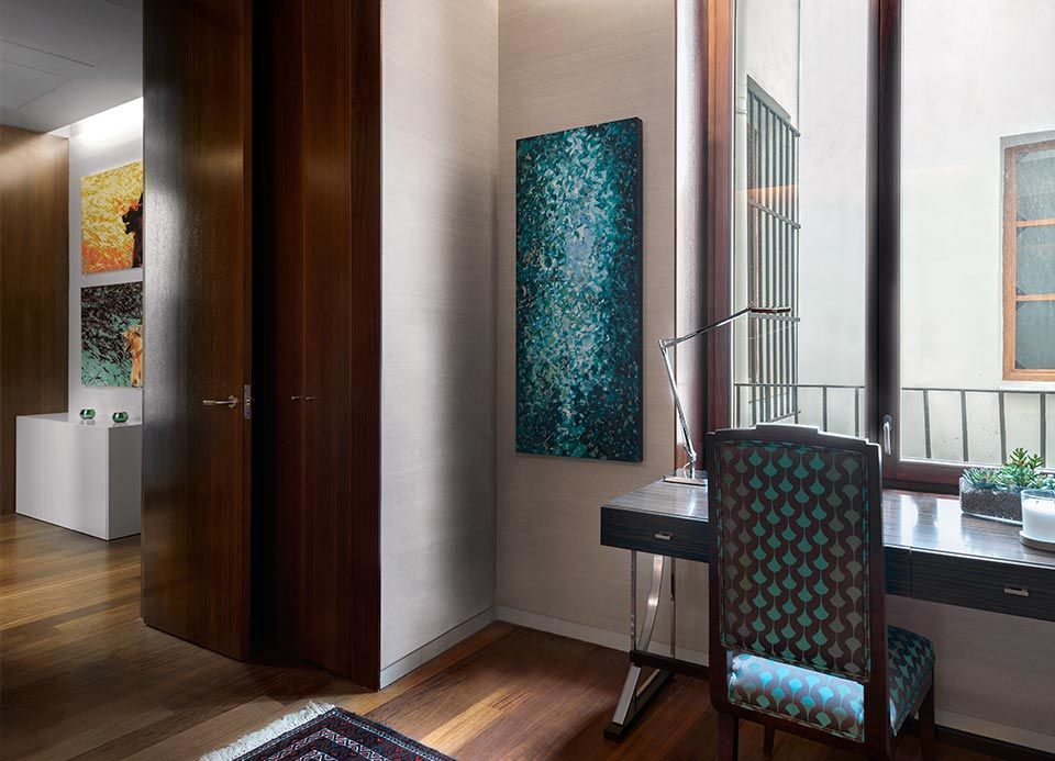 Una habitación con un escritorio, una silla y cuadros en la pared.