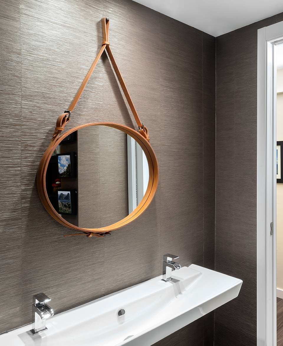 Un baño con un lavabo y un espejo en la pared.