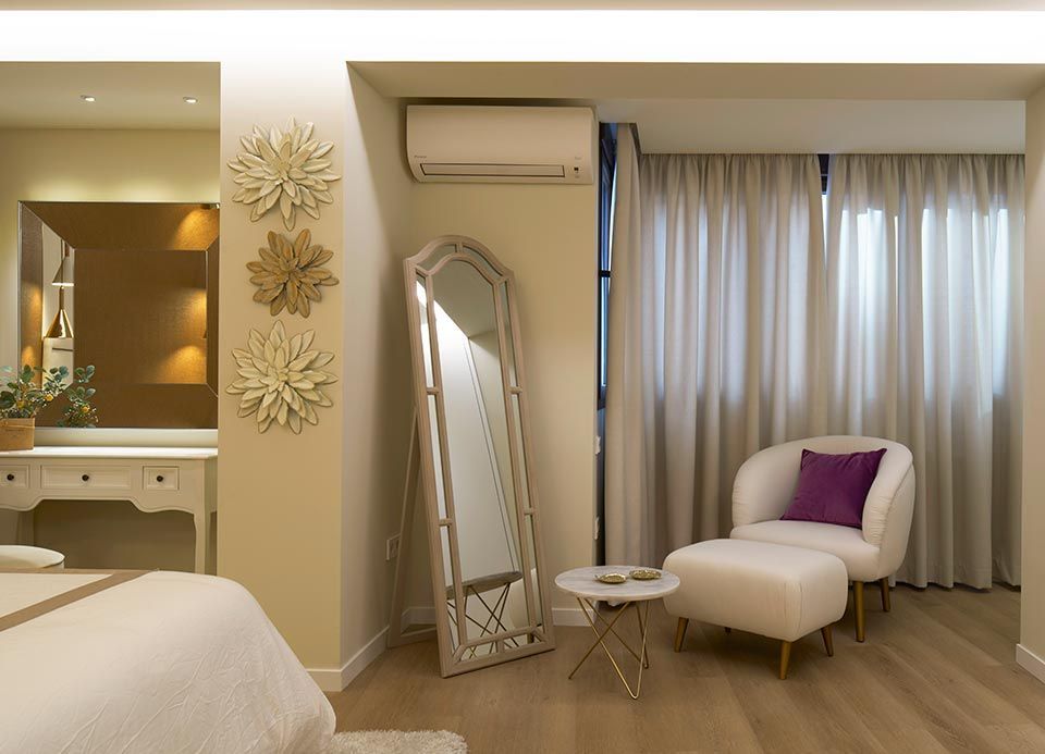 Un dormitorio con un espejo de cuerpo entero y una silla.