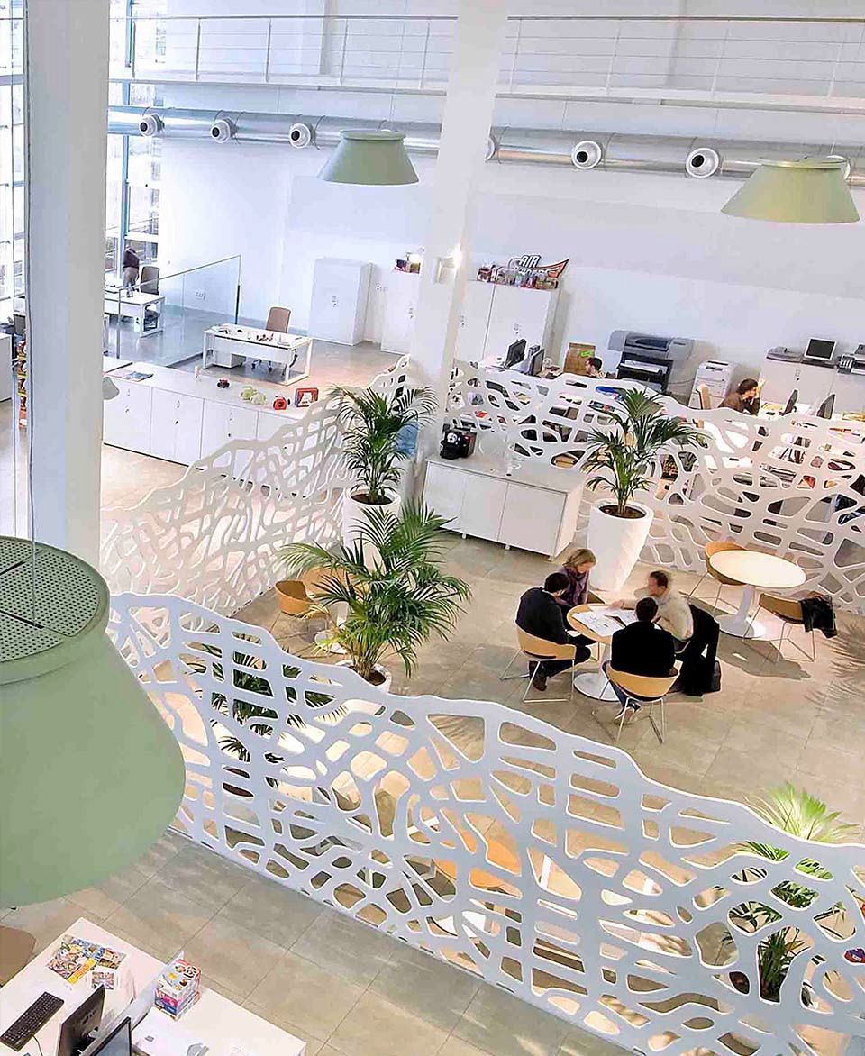 Un grupo de personas están sentadas en mesas en una sala grande.