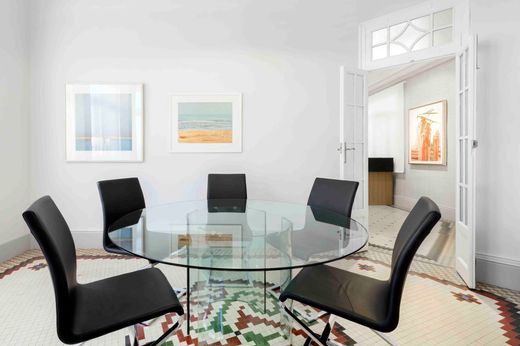 Un comedor con una mesa redonda de cristal y sillas negras.