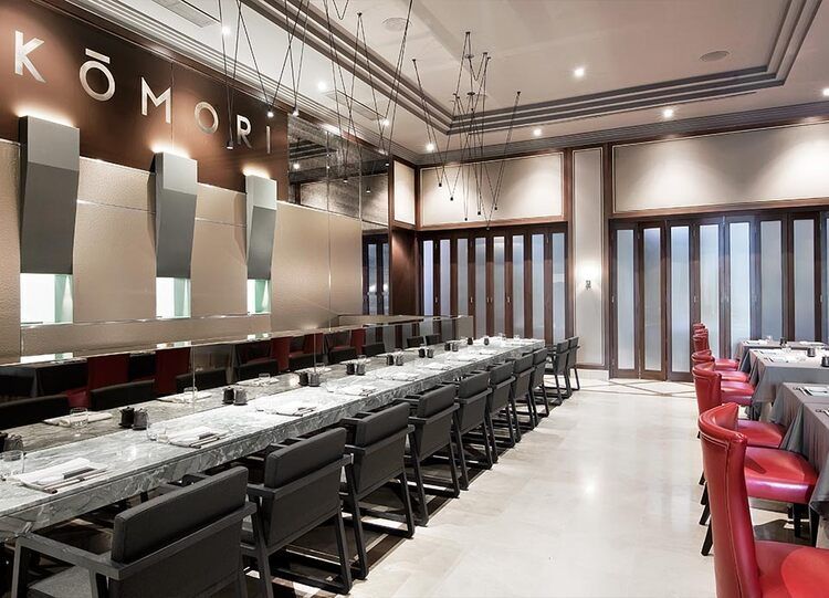 Una gran sala con mesas y sillas y la palabra komori en la pared.