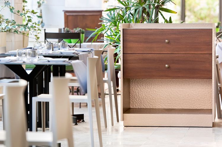 Un restaurante con mesas y sillas y una alacena de madera.