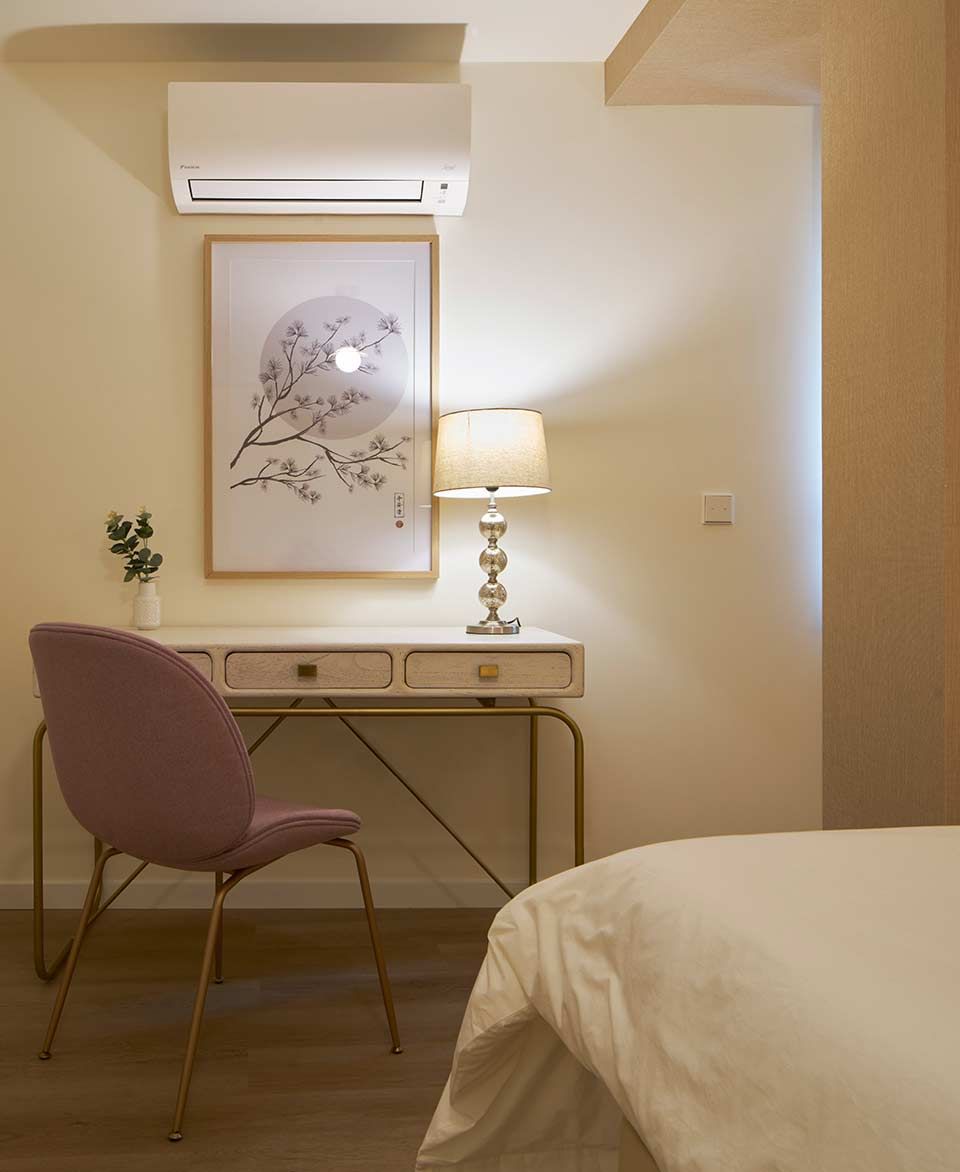 Un dormitorio con un escritorio, una silla, una lámpara y un cuadro en la pared.