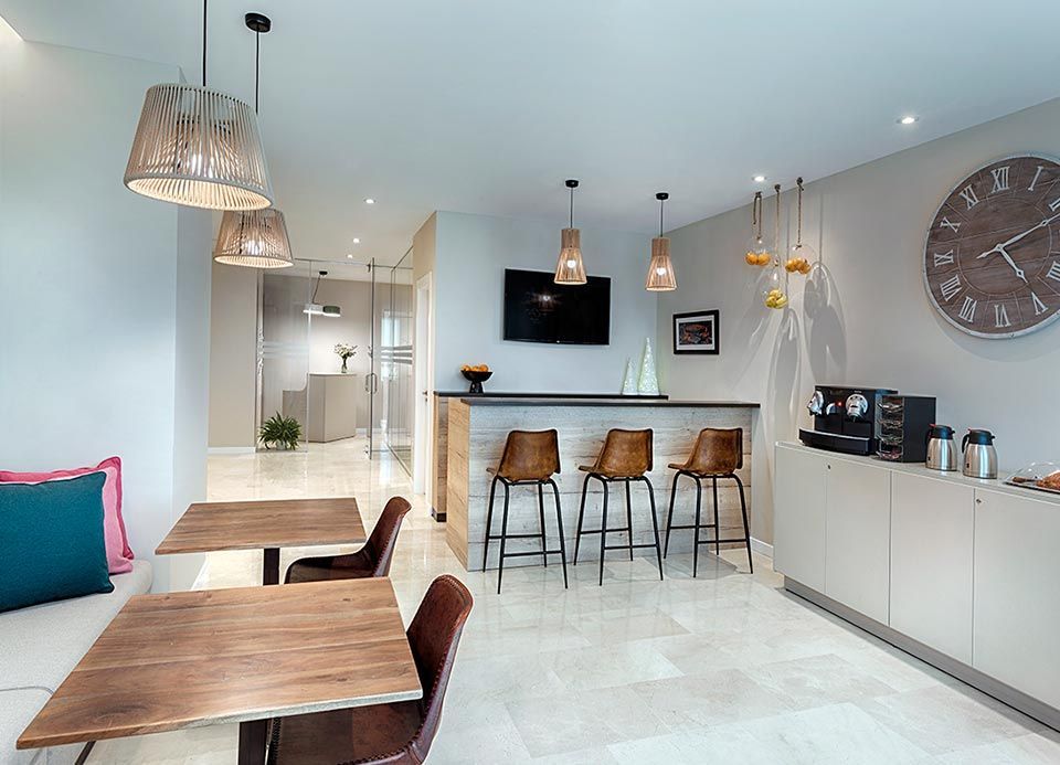 Una habitación con mesas y sillas y un reloj en la pared.