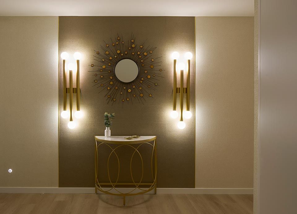 Un pasillo con una mesa y un espejo en la pared.