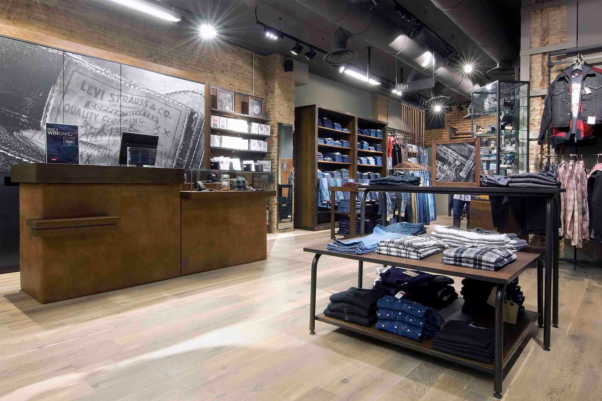 Una tienda llena de mucha ropa y un mostrador.